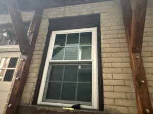 New white double hung window set in a brick wall in Pittsburgh, Alan Construction