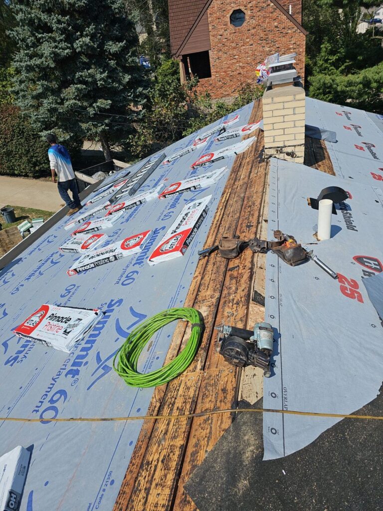 Underlayment going down around the chimney on a Bethel Park roof