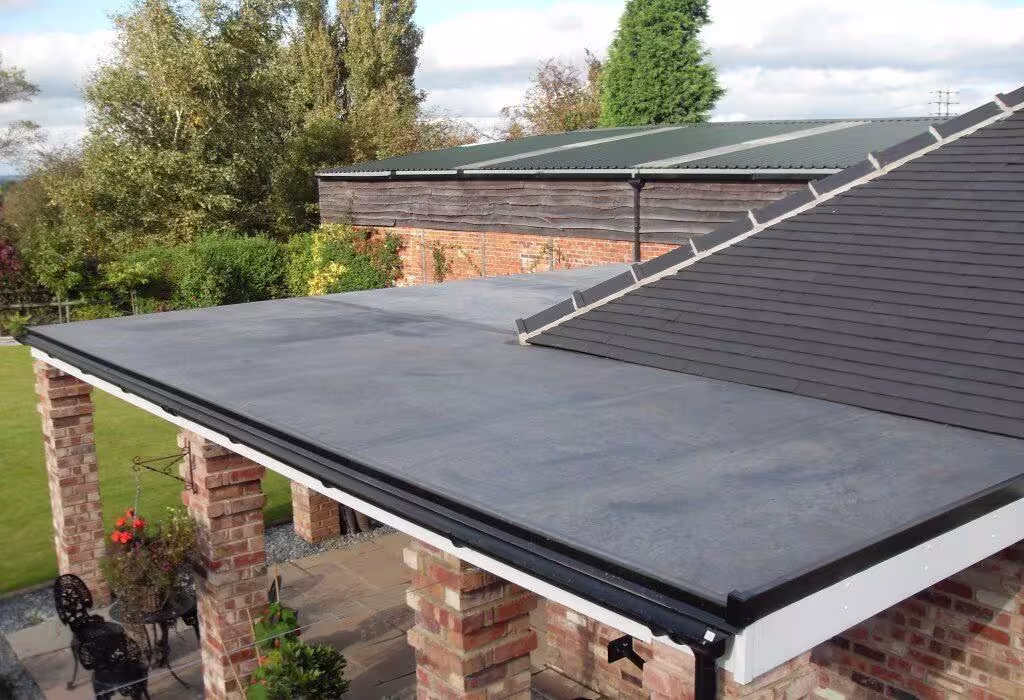 Rubber flat roof over a covered patio on brick columns, next to a shingled roof