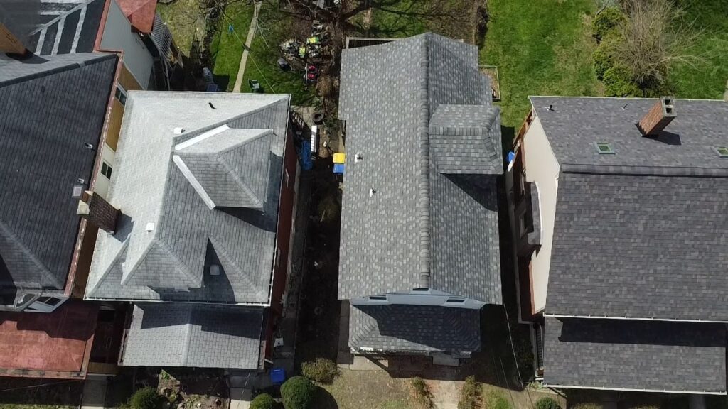 Aerial of a finished Dormont roof beside older neighboring roofs