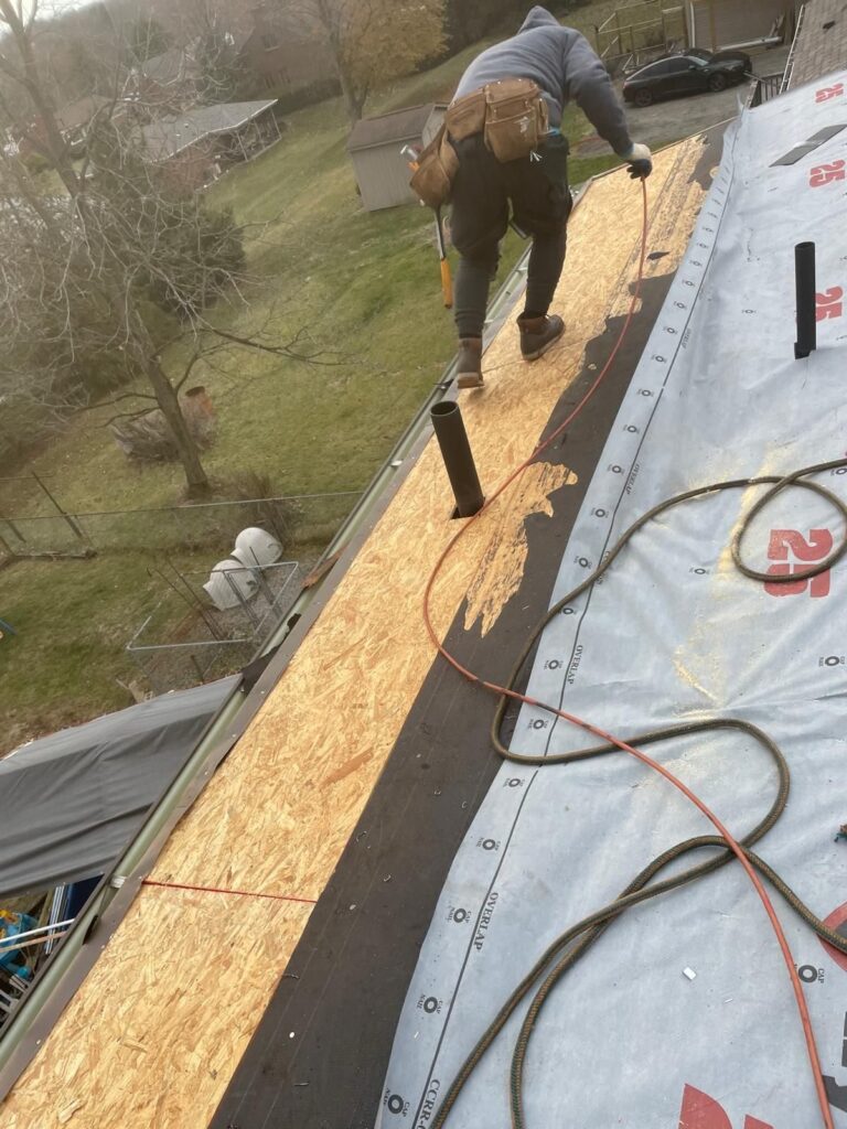 Roofer laying underlayment over new decking in Whitehall