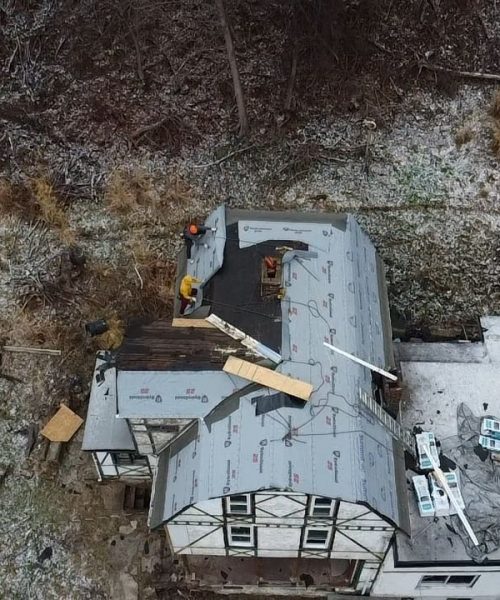 Drone view of a snowy house with underlayment and new decking in Pittsburgh, Alan Construction