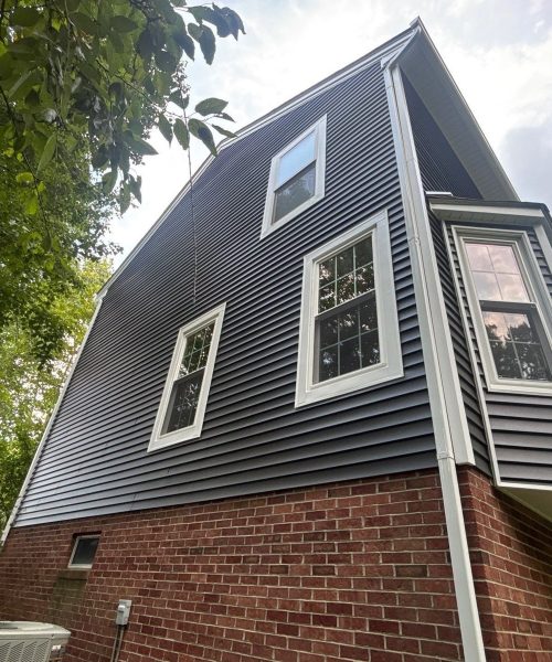 New dark gray vinyl siding on the upper story above a brick base in Pittsburgh, Alan Construction