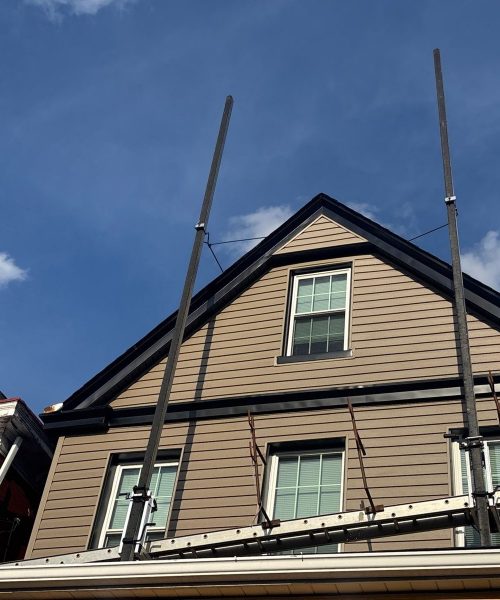 Gable end with new tan siding and black trim in Pittsburgh, Alan Construction