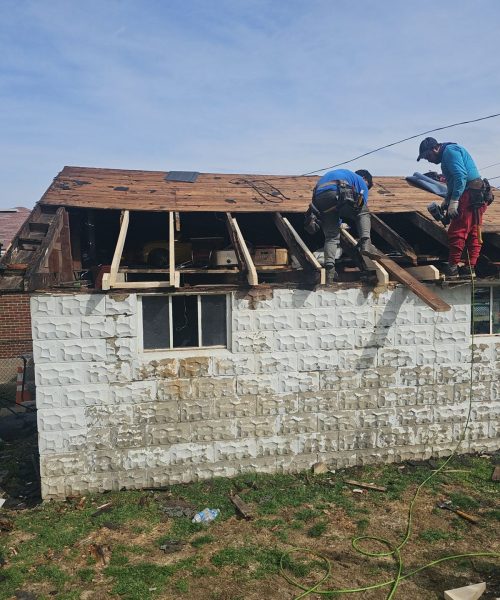 Roofer working on the new sheathing of a Brookline garage roof