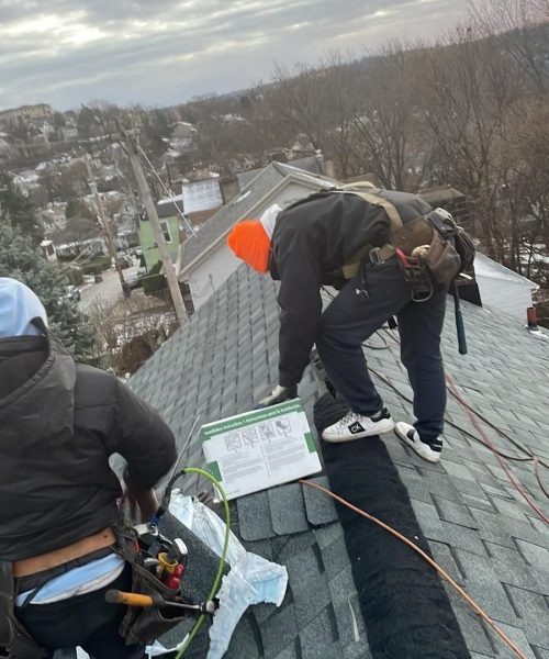 Crew installing new shingles on a Mount Washington roof