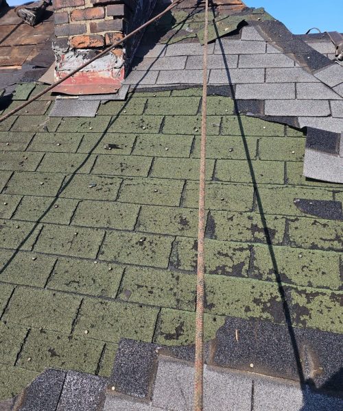 Worn shingles around the chimney on a Pittsburgh roof