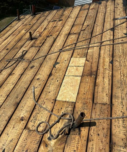 Old board deck with new sections patched in on a South Hills roof